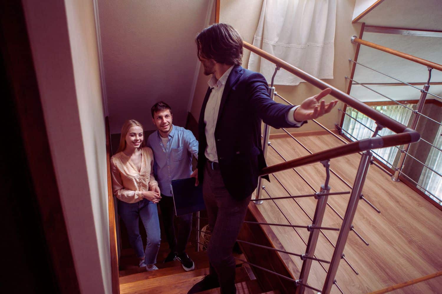 Une agente immobilière discutant avec un client potentiel devant une maison, illustrant l'approche révolutionnaire pour booster votre réussite en prospection immobilière.