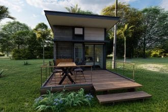 Une maison minuscule en bois avec des fenêtres panoramiques, un toit en pente et une petite terrasse extérieure. La question des prix des tiny houses est au cœur du débat sur le marché du logement durable.