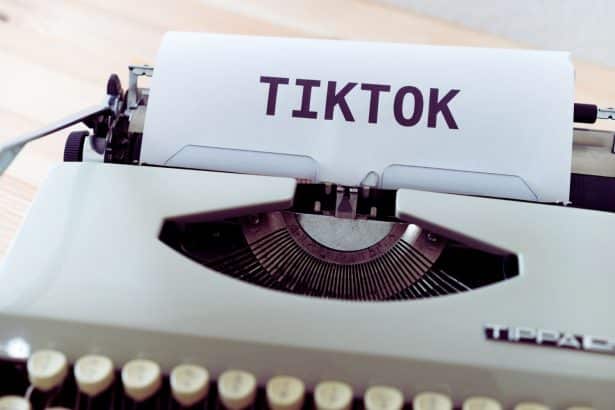 Une personne utilisant son smartphone pour créer du contenu TikTok de manière stratégique afin de capter et fidéliser son public.