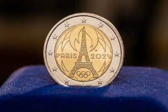 Photorealistic close-up of a polished Paris 2024 Olympic 2 euro coin featuring the Eiffel Tower and Olympic rings on dark blue velvet.