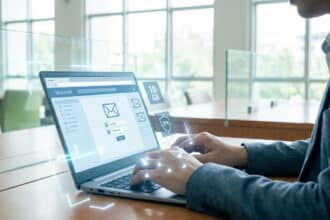 Homme tapant sur un PC portable affichant une page de connexion Webmail. Icônes 2FA et 10GB suggèrent sécurité et stockage moderne.