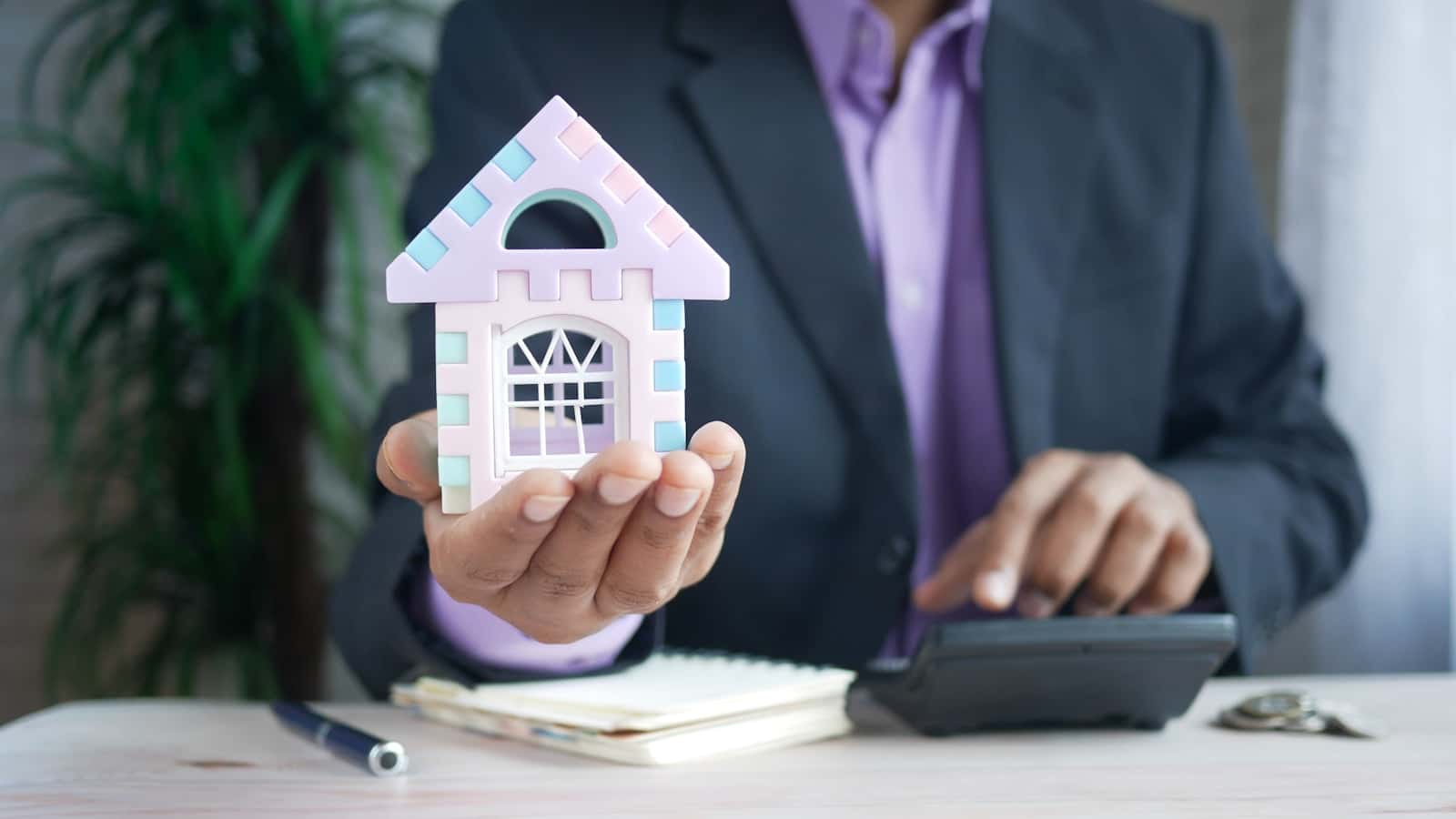 Maison miniature et calculatrice pour illustrer l’investissement immobilier en SCPI