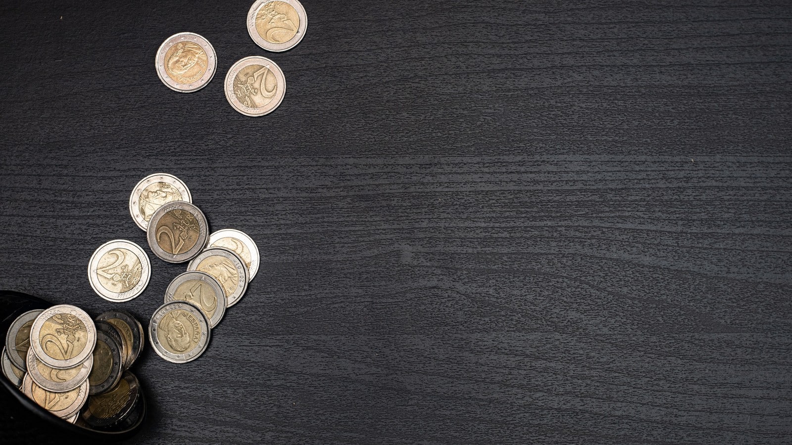 Pièces de deux euros disposées sur une table sombre pour illustrer la collection